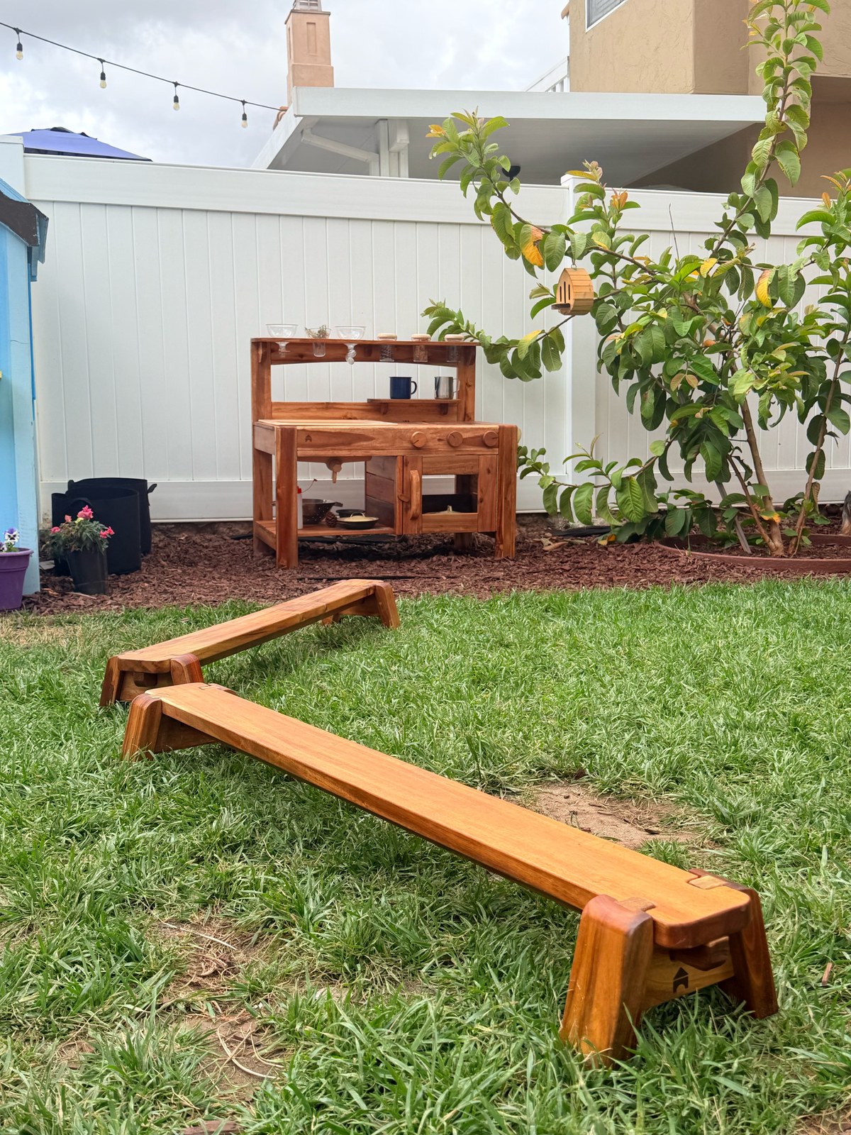 Wooden mud kitchen and balance beam in the backyard